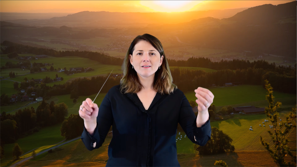 Still photo from video accompaniment for Dusk. Verena conducting in front of sunset near Salzburg, Austria.